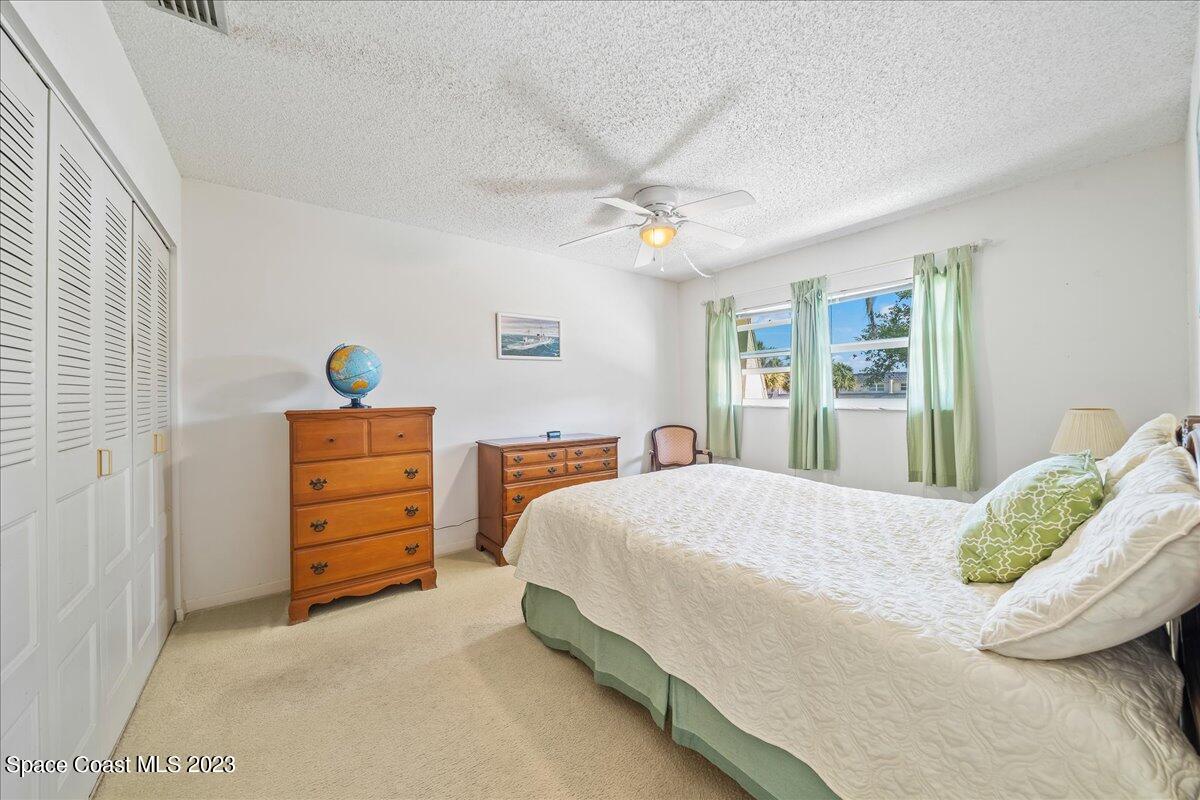 435 Dove Lane, Unit 810 Satellite Beach, FL 32937 - Photo 13 of 43 a bedroom with a bed and a chandelier