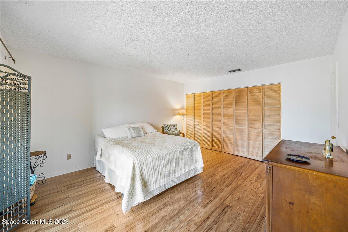 435 Dove Lane, Unit 810 Satellite Beach, FL 32937 - Photo 14 of 43 a bedroom with a bed and wooden floor