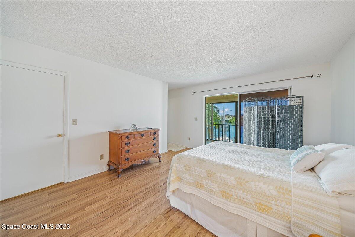 435 Dove Lane, Unit 810 Satellite Beach, FL 32937 - Photo 15 of 43 a bedroom with a bed and wooden floor