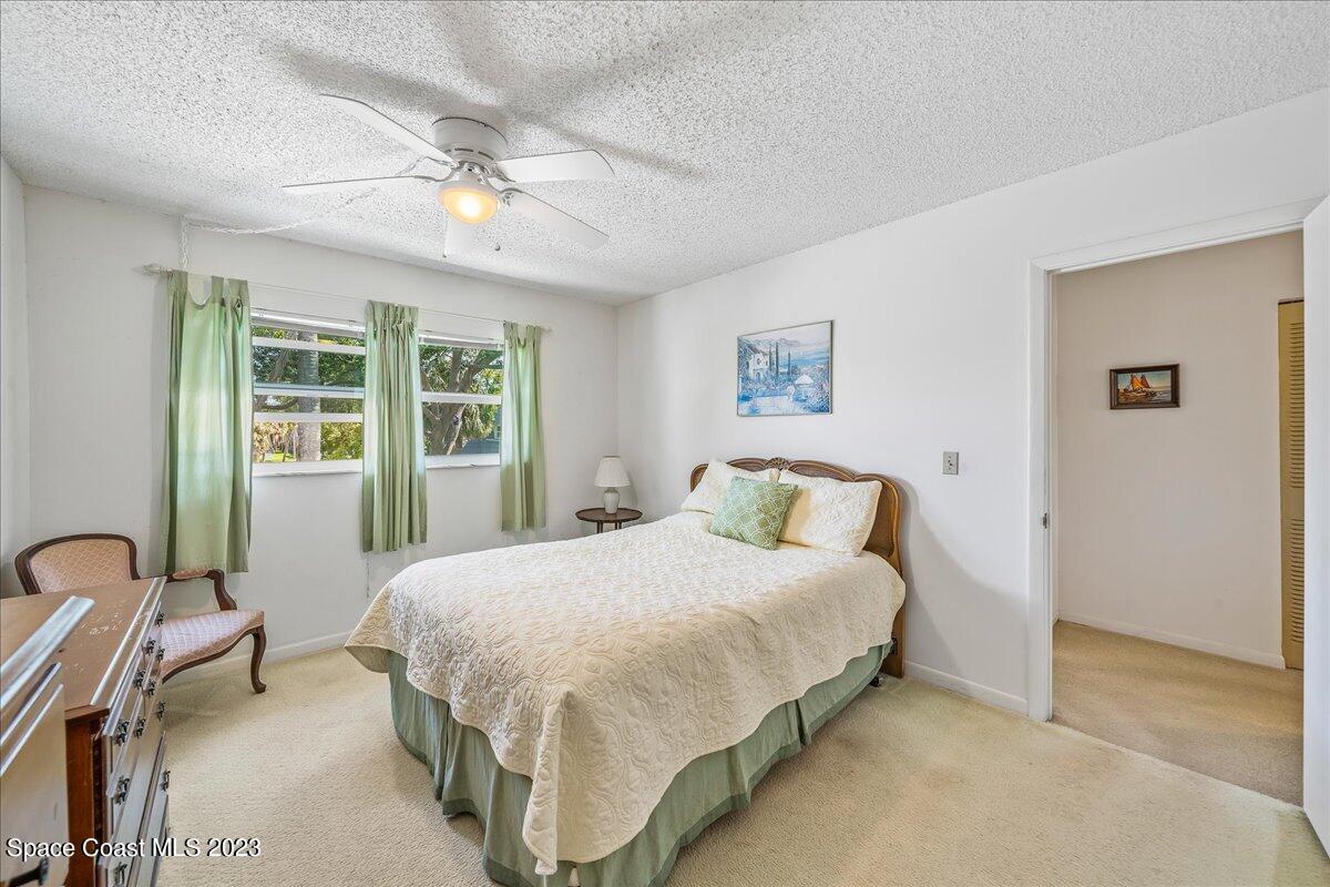 435 Dove Lane, Unit 810 Satellite Beach, FL 32937 - Photo 16 of 43 a bedroom with a large bed and a chandelier