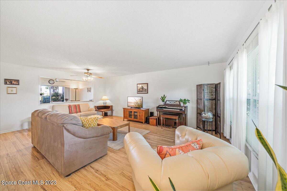 435 Dove Lane, Unit 810 Satellite Beach, FL 32937 - Photo 5 of 43 a living room with fireplace furniture and a large window