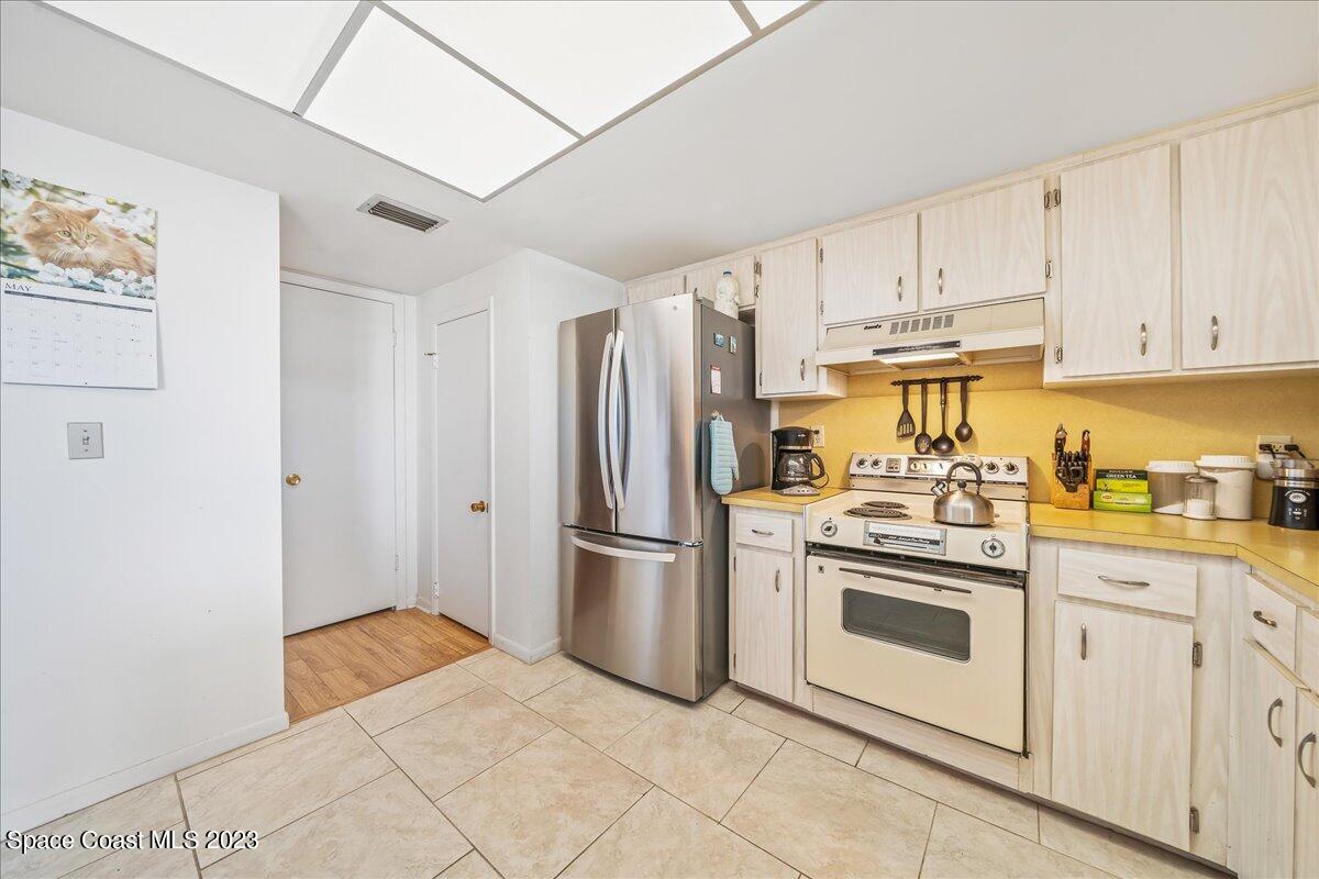 435 Dove Lane, Unit 810 Satellite Beach, FL 32937 - Photo 7 of 43 a kitchen with stainless steel appliances granite countertop a refrigerator and a stove top oven