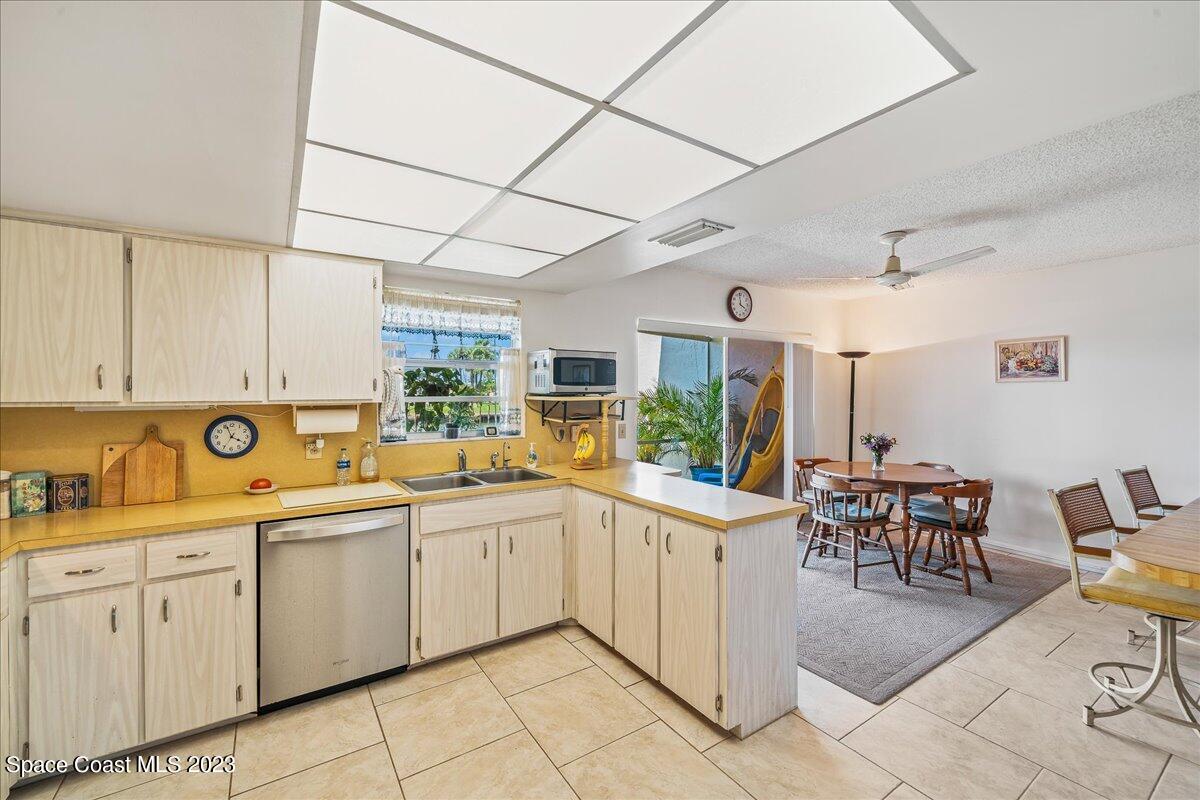 435 Dove Lane, Unit 810 Satellite Beach, FL 32937 - Photo 8 of 43 a kitchen with a sink and chairs