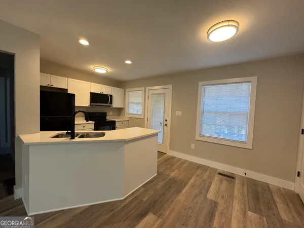 a kitchen with a refrigerator and a stove top oven