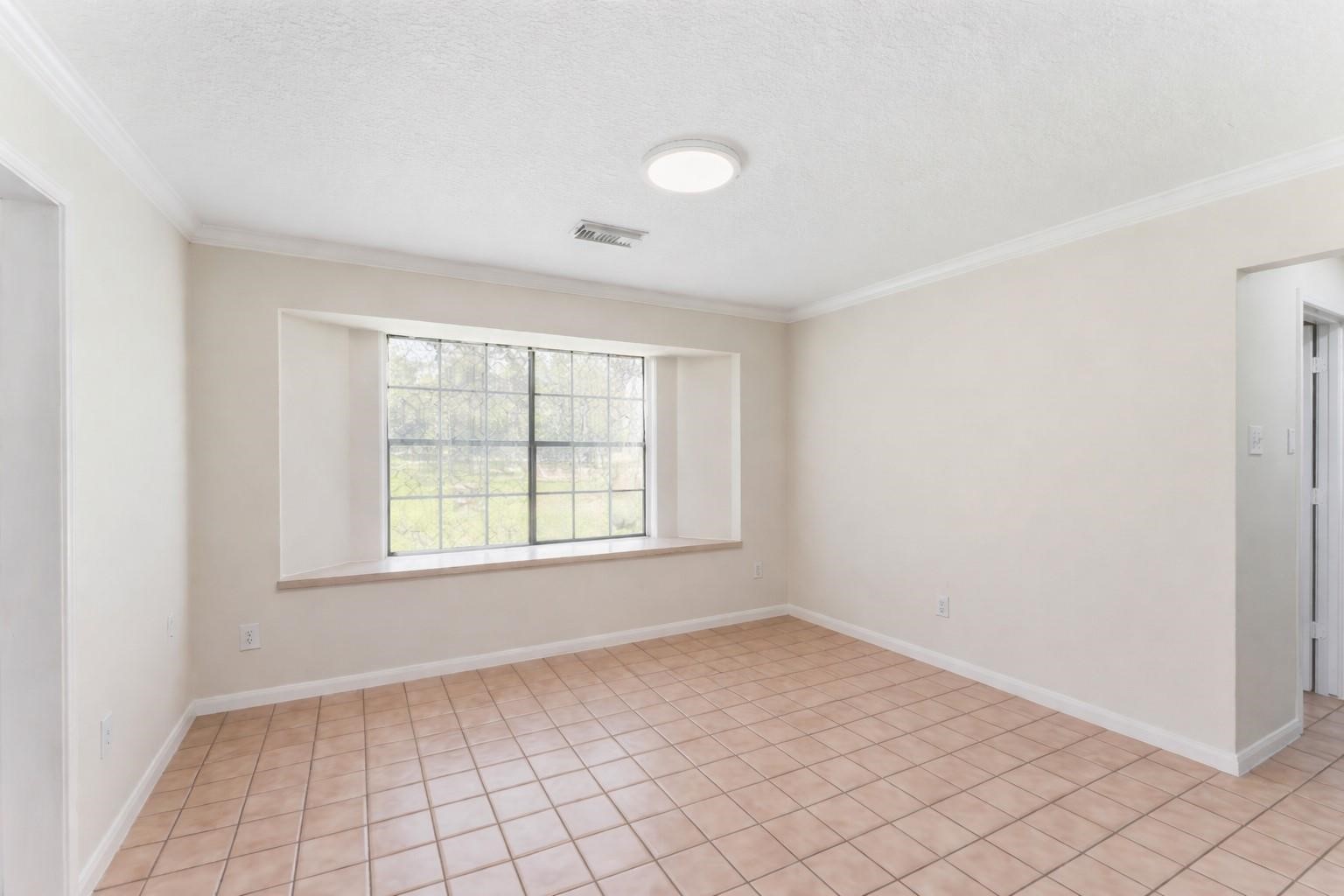 7825 Hughes Ranch Road Pearland, TX 77581 - Photo 11 of 28 The kitchen flows naturally into a casual breakfast area — bright, relaxed, and inviting with new granite surfaces and generous cabinetry perfect for easy morning routines.