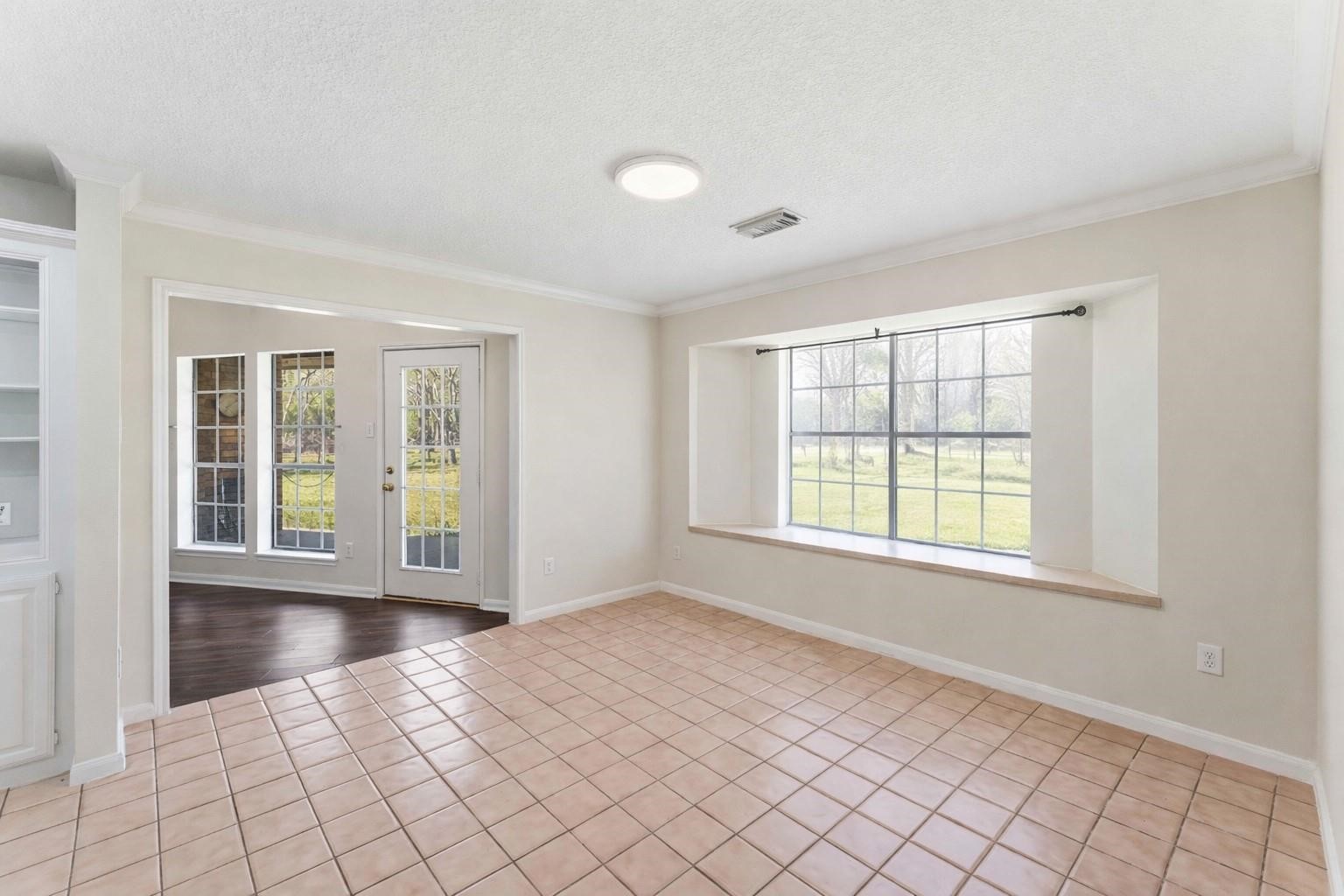 7825 Hughes Ranch Road Pearland, TX 77581 - Photo 12 of 28 This angle tells the full story — the casual dining space flows naturally and openly into the family room, creating a connected, easy living layout.