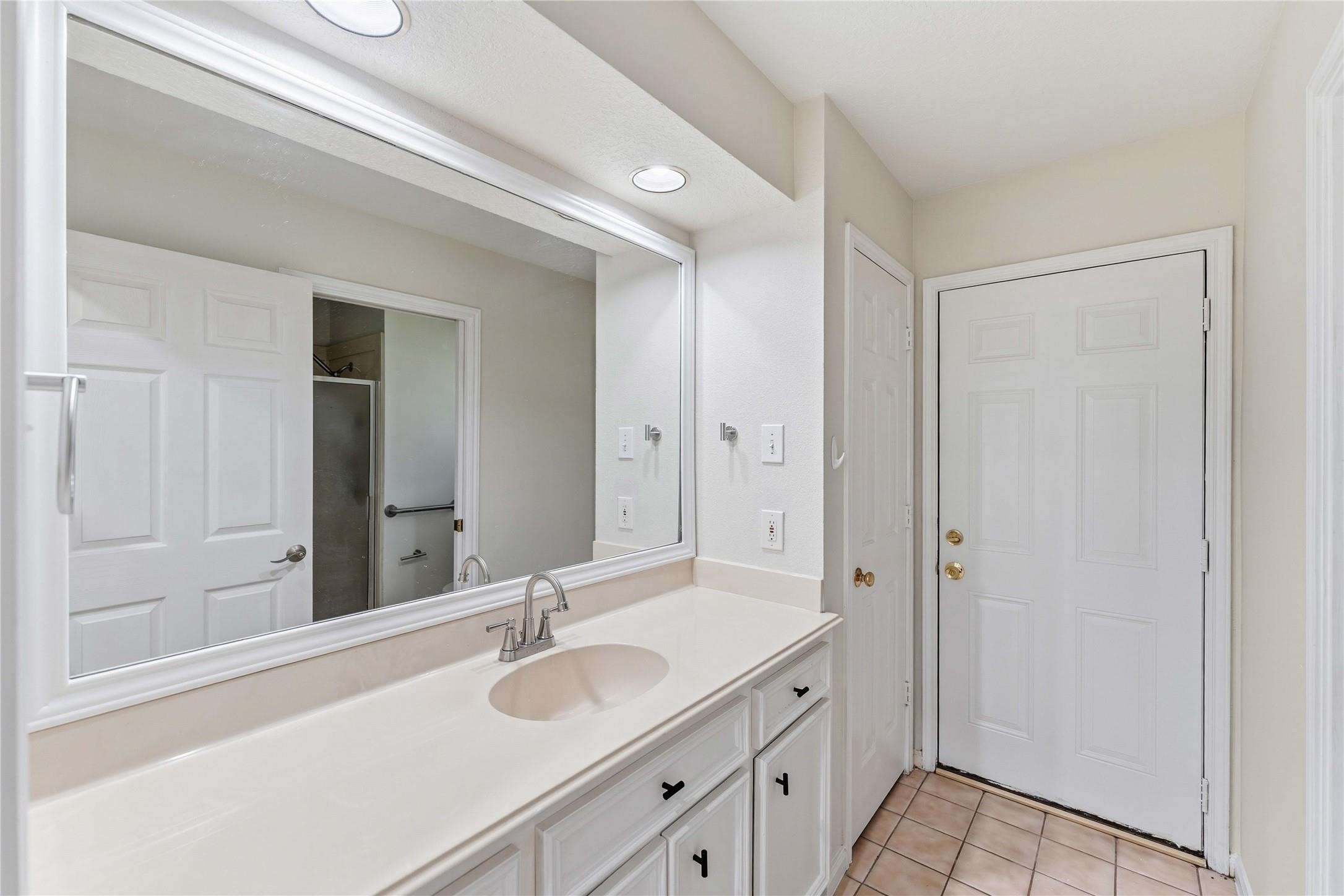 7825 Hughes Ranch Road Pearland, TX 77581 - Photo 20 of 28 The secondary bath offers a step-in shower, natural light, and updated fixtures — clean, functional, and move-in ready.