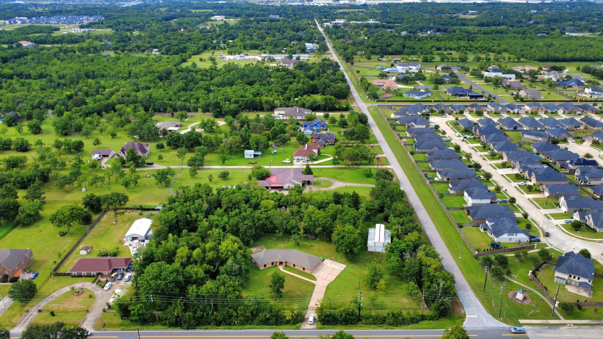 7825 Hughes Ranch Road Pearland, TX 77581 - Photo 28 of 28 This aerial says everything words can't. Three private acres tucked behind a canopy of mature trees — and right across the street, a traditional subdivision. No HOA. No shared walls. No compromise. Just space, privacy, with a desirable Pearland address. One last look at a property that doesn't come around twice.