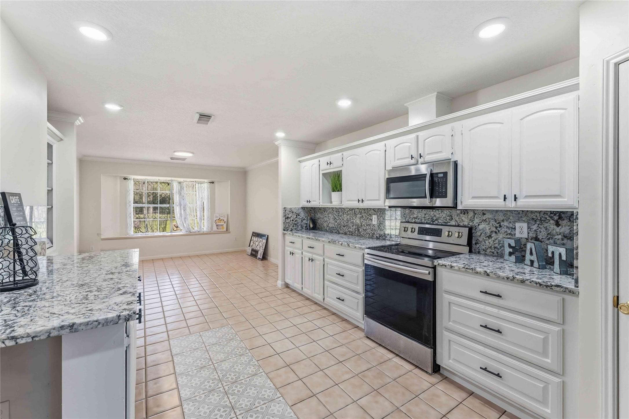 7825 Hughes Ranch Road Pearland, TX 77581 - Photo 9 of 28 Organized and functional, the kitchen's island-style serving area, generous built-in shelving, and stainless steel appliances make it equally suited for weeknight dinners and weekend entertaining.
