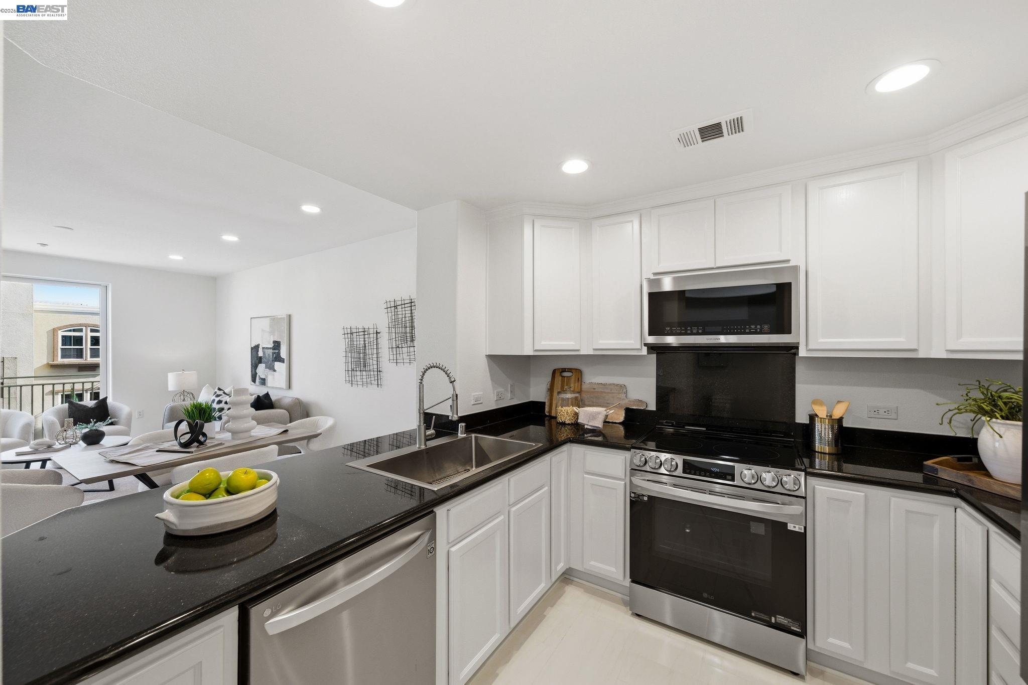 49002 Cinnamon Fern Common, Unit 507 Fremont, CA 94539 - Photo 12 of 41 a kitchen with sink a stove and cabinets