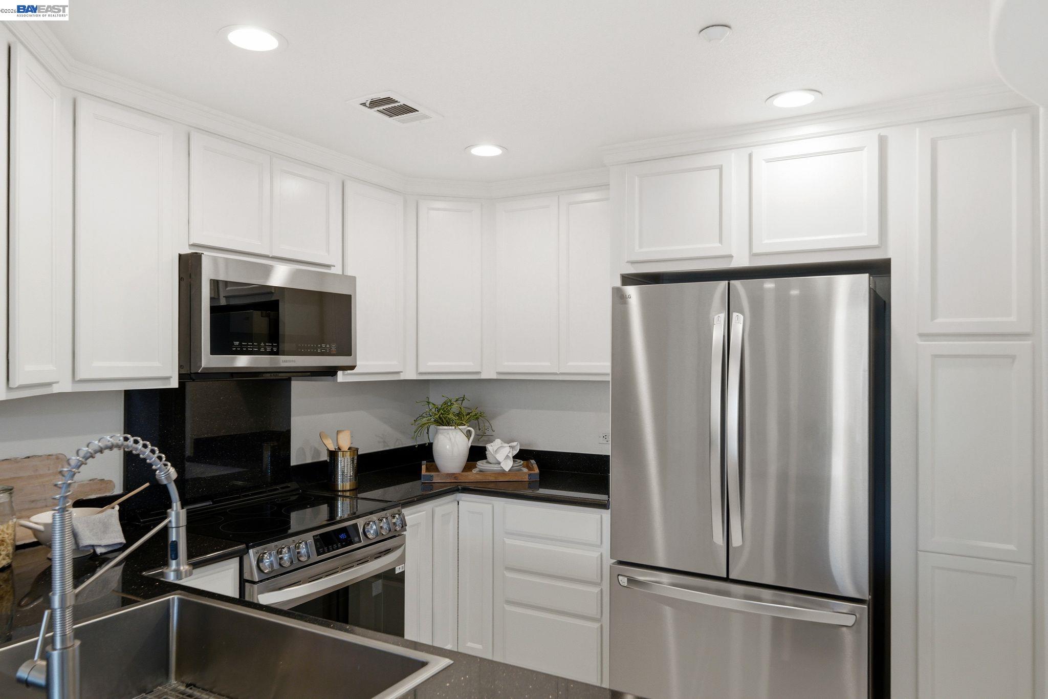 49002 Cinnamon Fern Common, Unit 507 Fremont, CA 94539 - Photo 13 of 41 a kitchen with a refrigerator a stove top oven a sink and dishwasher