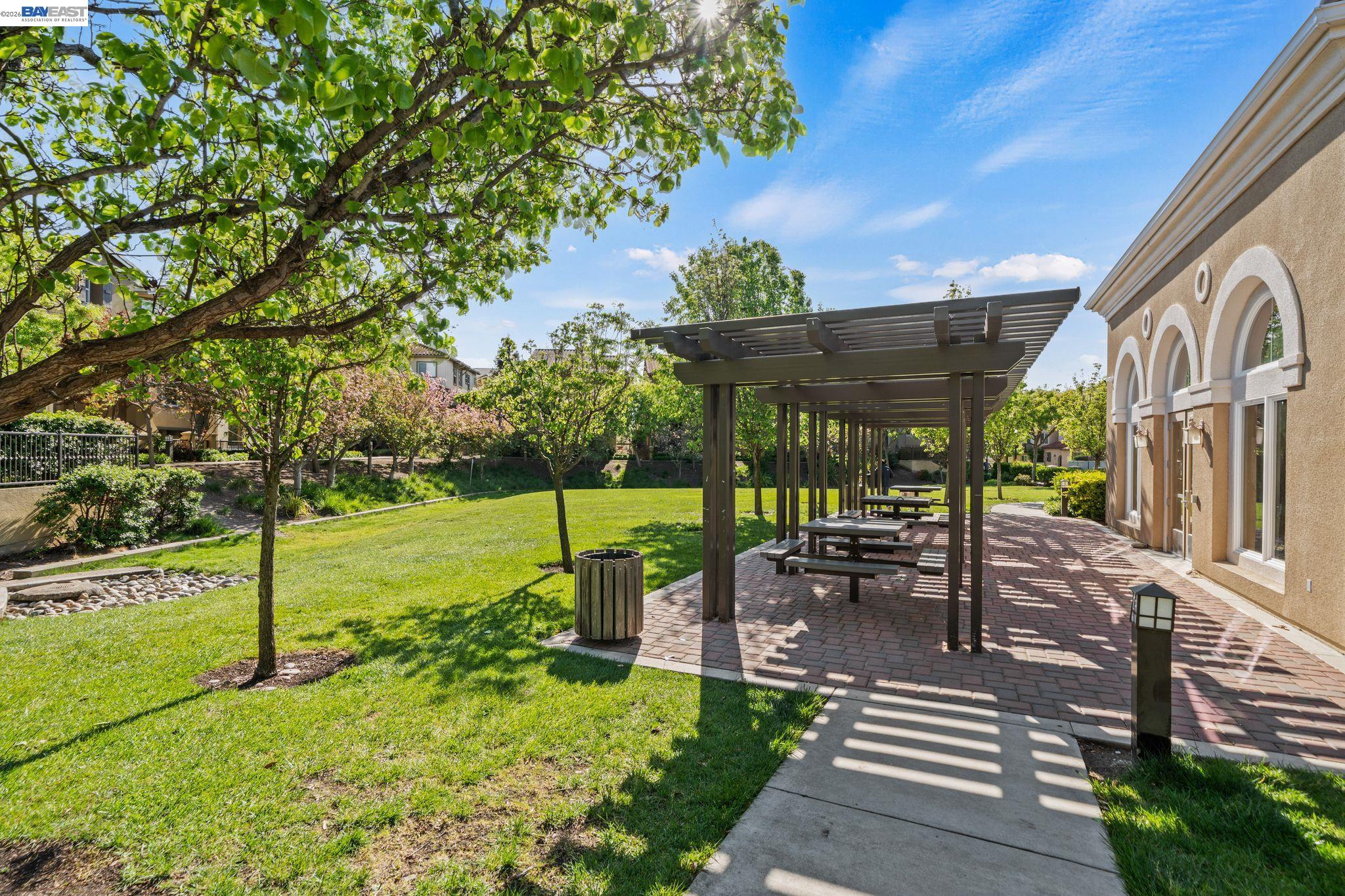 49002 Cinnamon Fern Common, Unit 507 Fremont, CA 94539 - Photo 37 of 41 a view of a patio with table and chairs potted plants with large tree