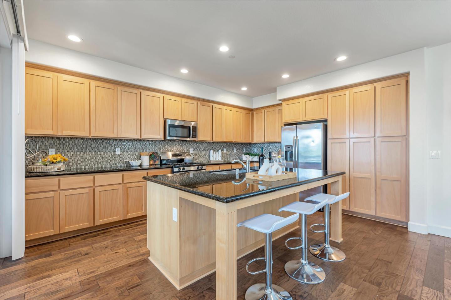 103 Incense Terrace Sunnyvale, CA 94086 - Photo 12 of 42 a kitchen with stainless steel appliances granite countertop a stove a sink a microwave a refrigerator and cabinets