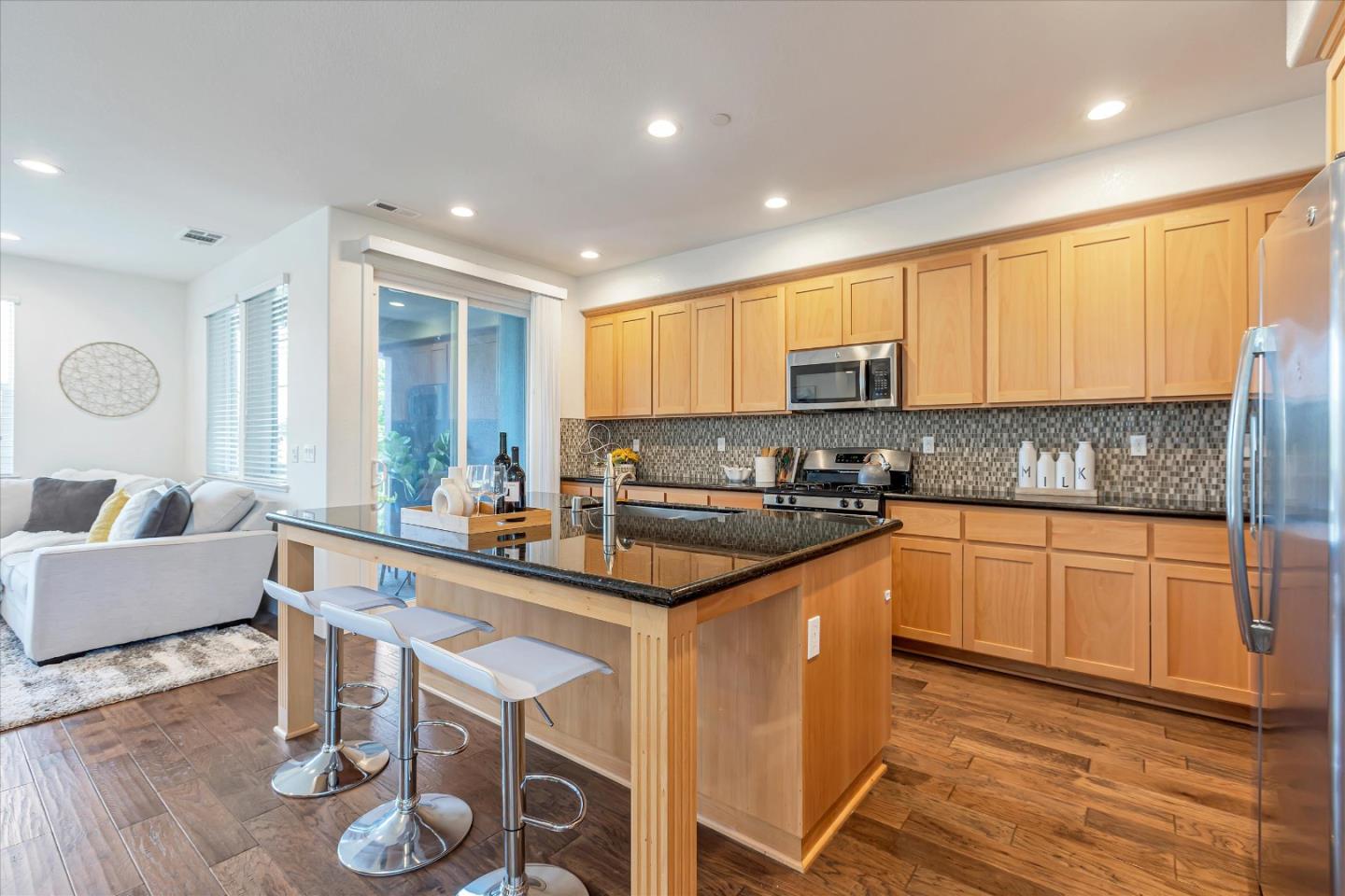 103 Incense Terrace Sunnyvale, CA 94086 - Photo 8 of 42 a kitchen with kitchen island granite countertop wooden floors and white cabinets