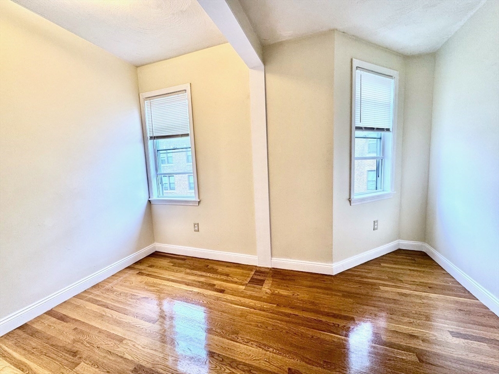 6 Calder Street, Unit 3 Boston, MA 02124 - Photo 12 of 23 an empty room with wooden floor and windows