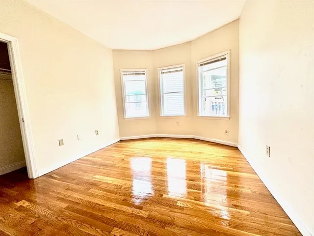a view of a room with wooden floor and a window