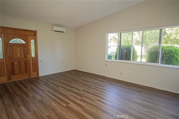 a view of empty room with wooden floor and window
