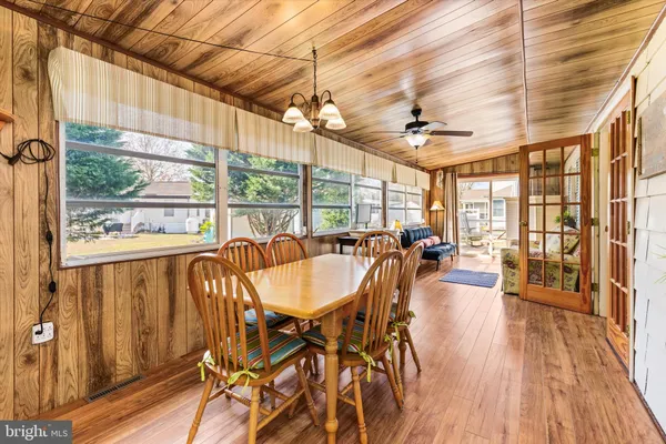 a dining room with wooden floor glass table and chairs