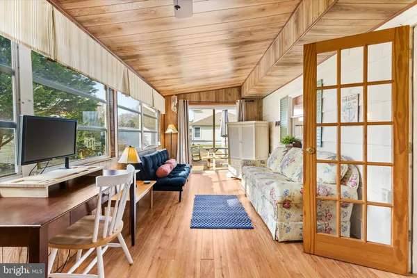 a living room with furniture wooden floor and a flat screen tv