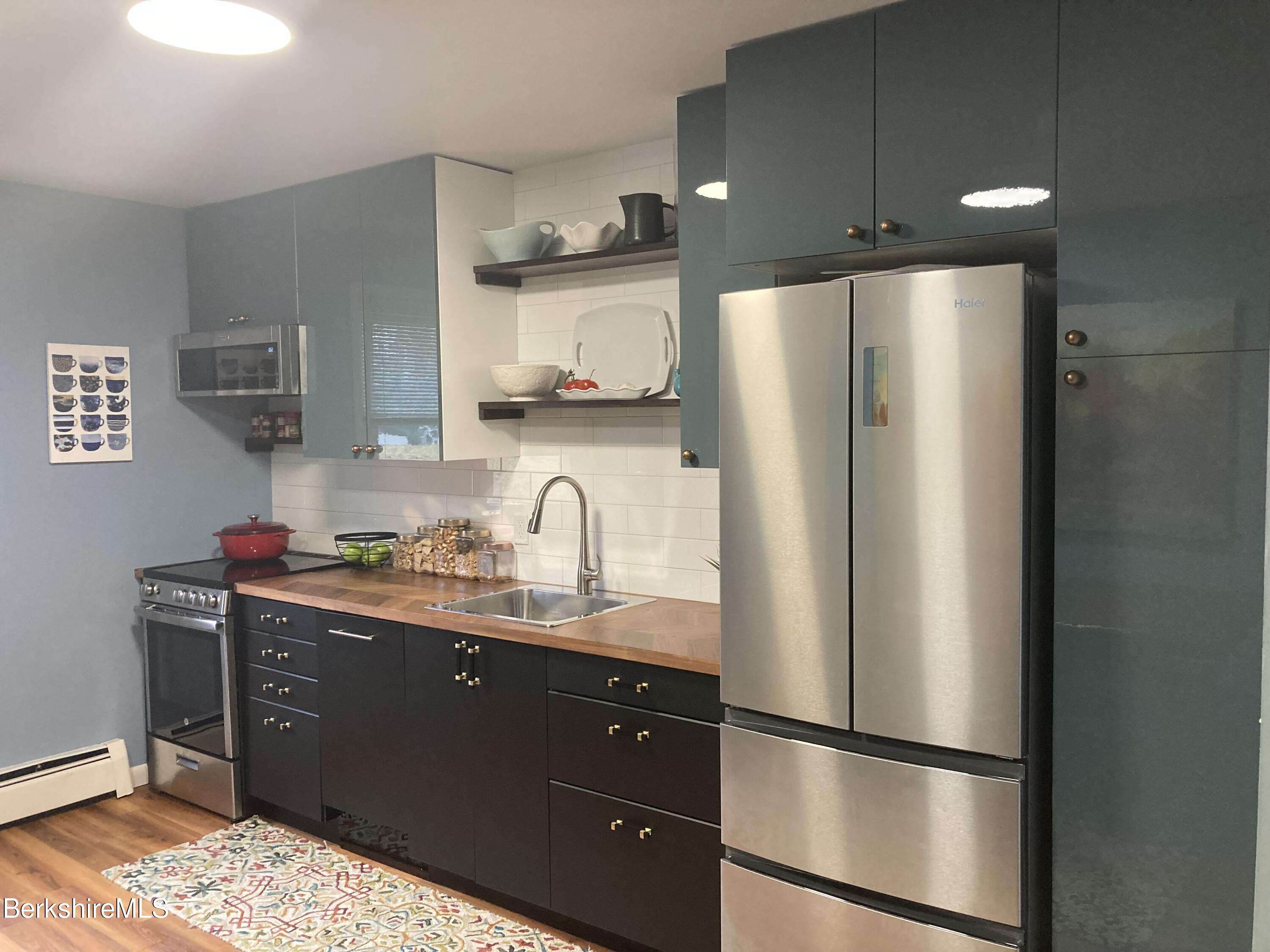 2 Morgan Manor, Unit 6 Lenox, MA 01240 - Photo 13 of 32 a kitchen with stainless steel appliances granite countertop a refrigerator a sink and white cabinets
