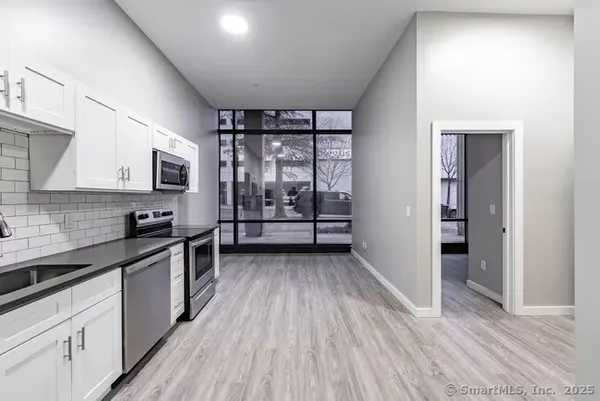 a kitchen with stainless steel appliances granite countertop a stove and a wooden floors