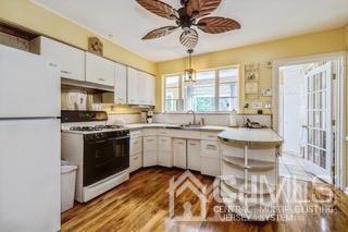 237 Amboy Road Old Bridge, NJ 07747 - Photo 16 of 39 a kitchen with a sink cabinets stainless steel appliances and a large window