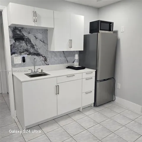 a kitchen with stainless steel appliances white cabinets and a refrigerator