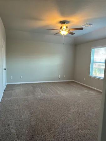 an empty room that has a window and chandelier