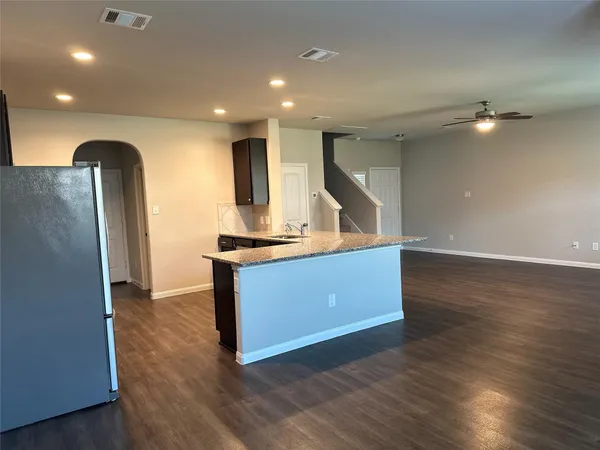 a view of kitchen with refrigerator and wooden floor
