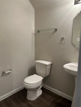 a white toilet sitting next to a white sink and vanity
