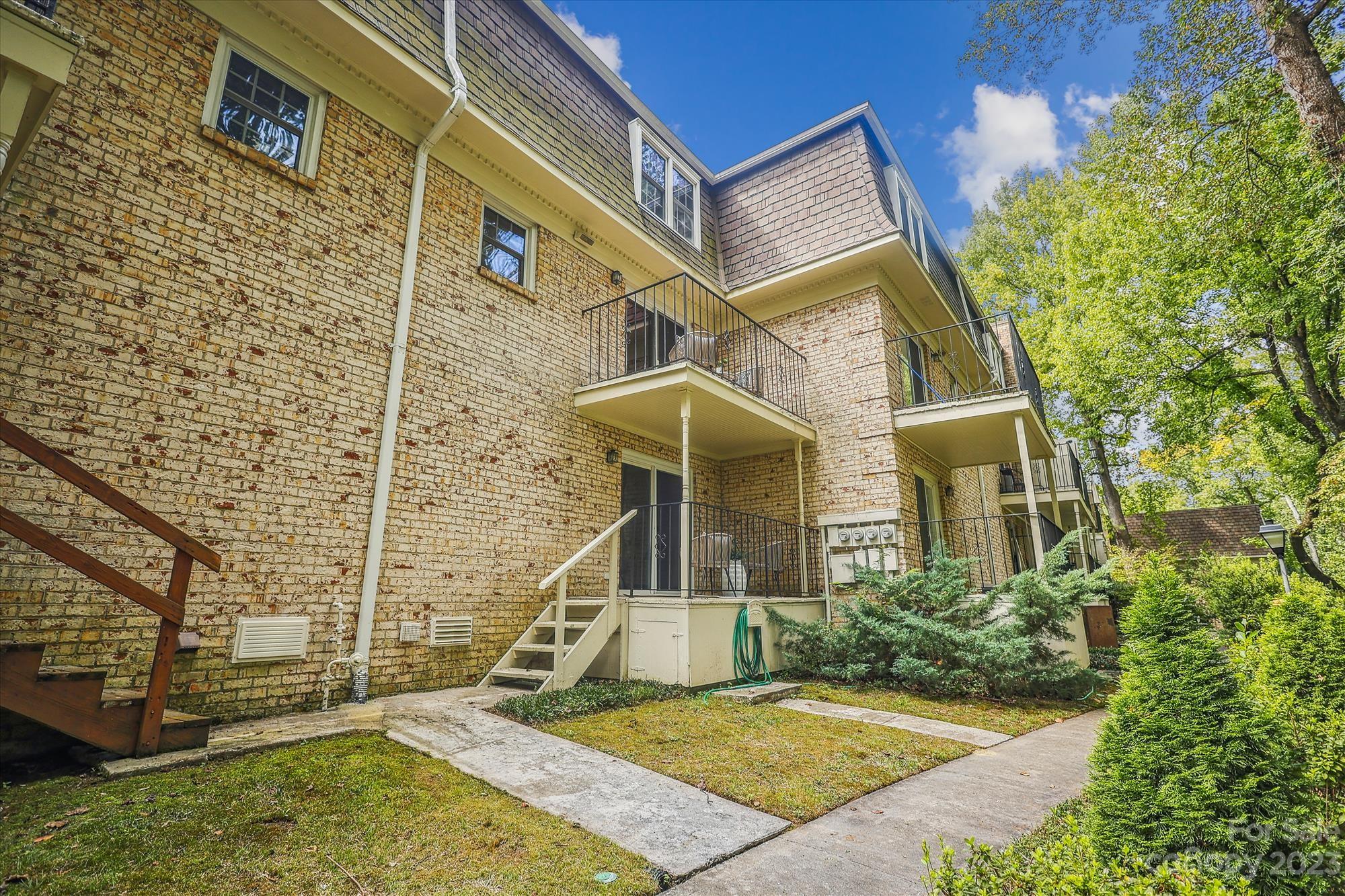 3504 Colony Road, Unit N Charlotte, NC 28211 - Photo 32 of 40 a view of a brick house with large windows and a yard