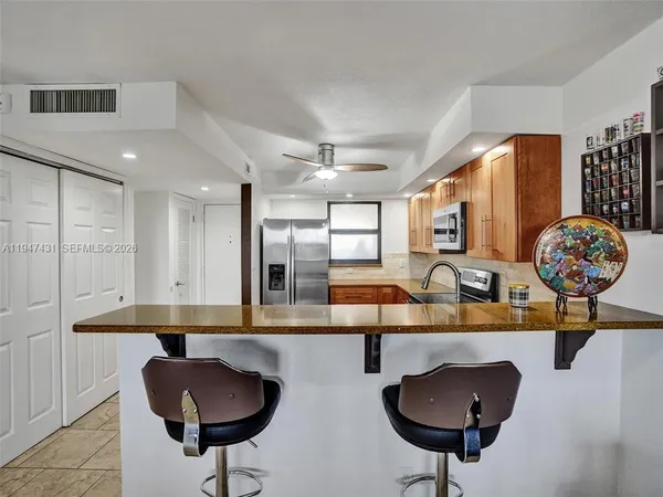 a kitchen with stainless steel appliances kitchen island granite countertop a sink and cabinets