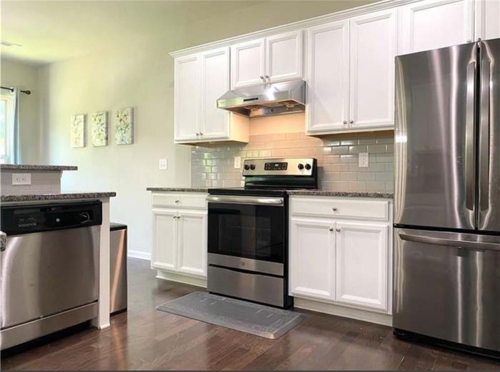 1719 Charcoal Ives Road Lawrenceville, GA 30045 - Photo 5 of 17 a kitchen with stainless steel appliances granite countertop white cabinets a refrigerator a sink and a stove