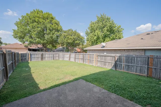 a view of a backyard with a small cabin and wooden fence