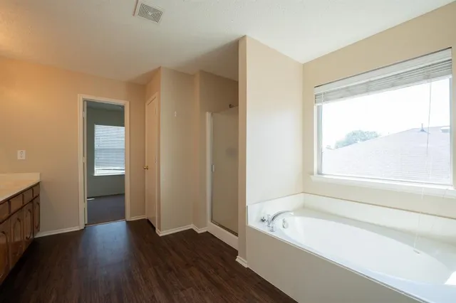 a bathroom with a bathtub a toilet and a window