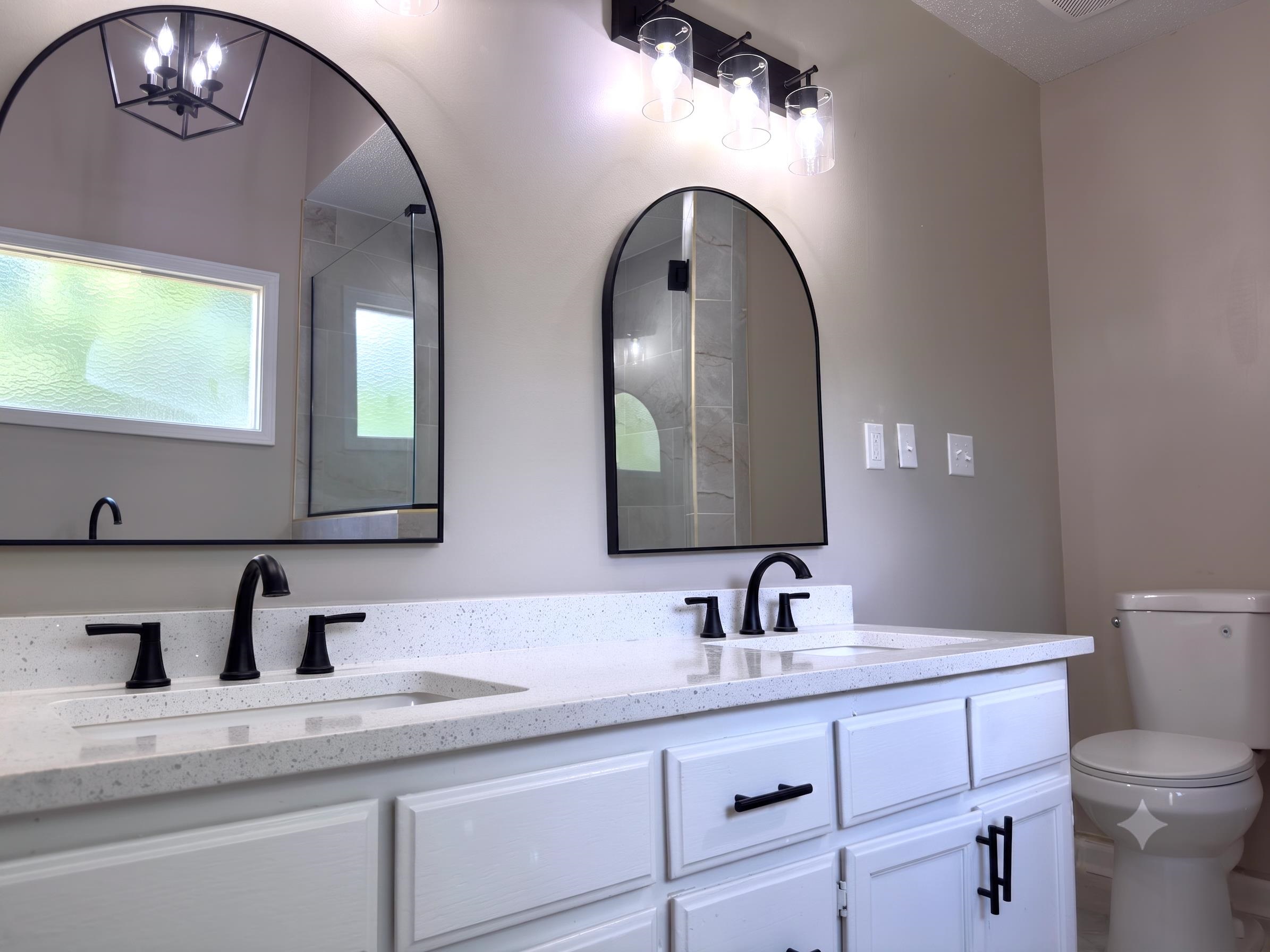 927 Cully Road Memphis, TN 38018 - Photo 14 of 33 Bathroom featuring a double vanity with stone countertops, integrated sinks, and matte black fixtures