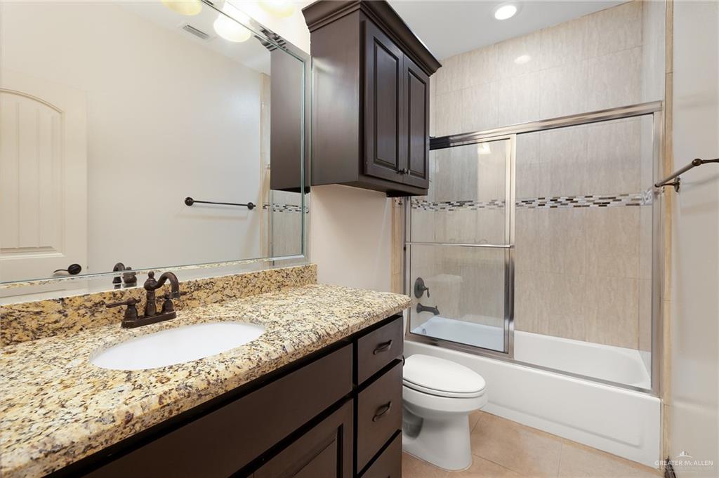 7027 North 3rd Street, Unit 7027 McAllen, TX 78504 - Photo 12 of 14 a bathroom with a granite countertop sink toilet and shower
