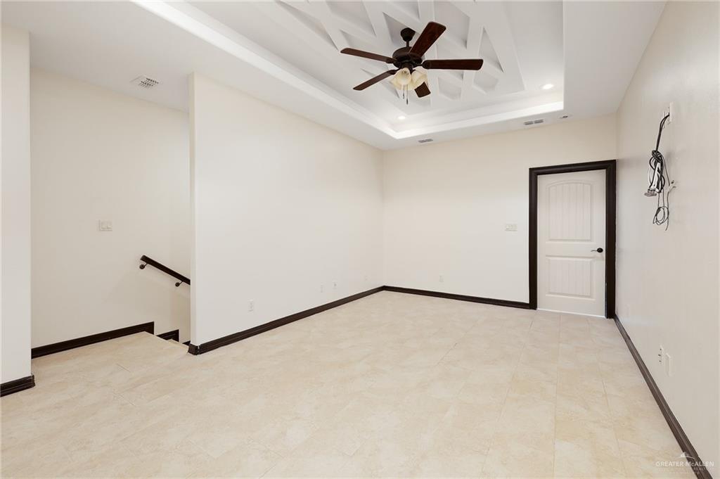 7027 North 3rd Street, Unit 7027 McAllen, TX 78504 - Photo 8 of 14 an empty room with a ceiling fan and wooden floor
