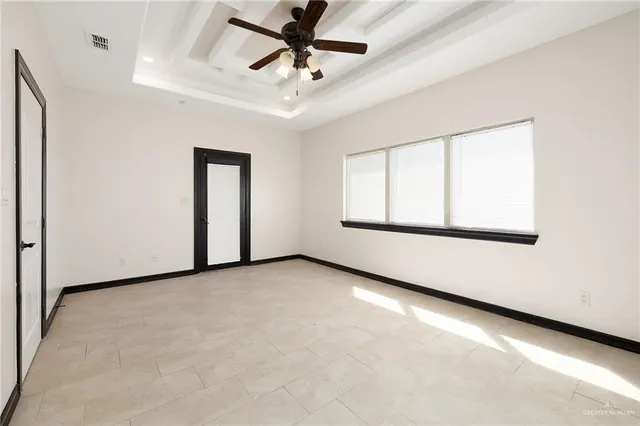 an empty room with windows and fan