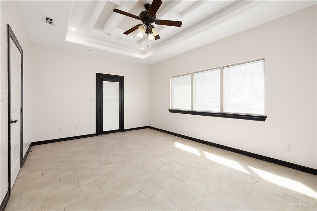 7027 North 3rd Street, Unit 7027 McAllen, TX 78504 - Photo 9 of 14 an empty room with windows and fan