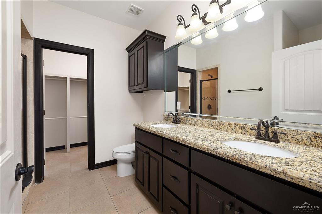 7027 North 3rd Street, Unit 7027 McAllen, TX 78504 - Photo 10 of 14 a bathroom with a granite countertop sink a light fixture and a mirror