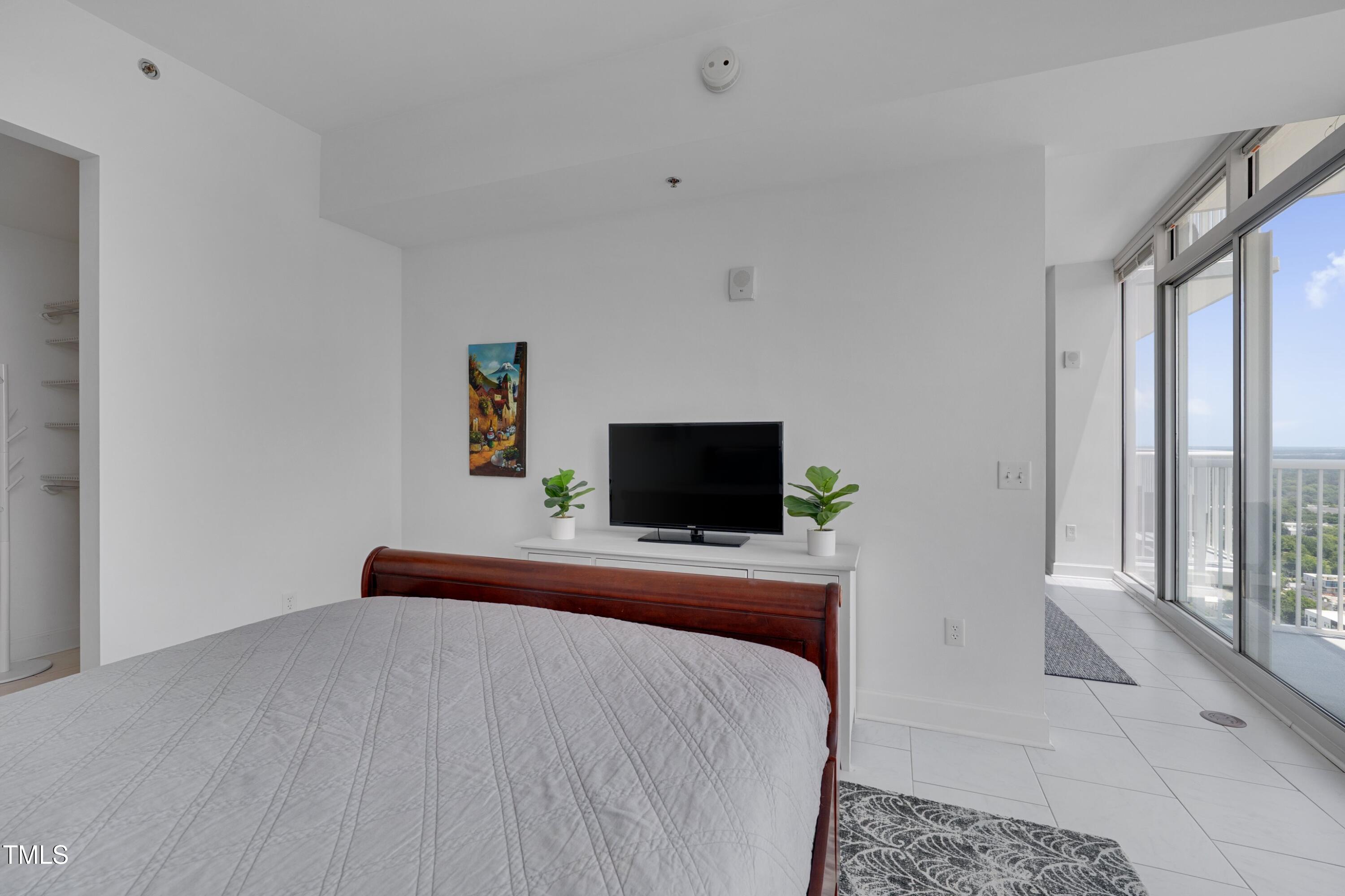 301 Fayetteville Street, Unit 2611 Raleigh, NC 27601 - Photo 10 of 44 a bedroom with a bed and a flat screen tv
