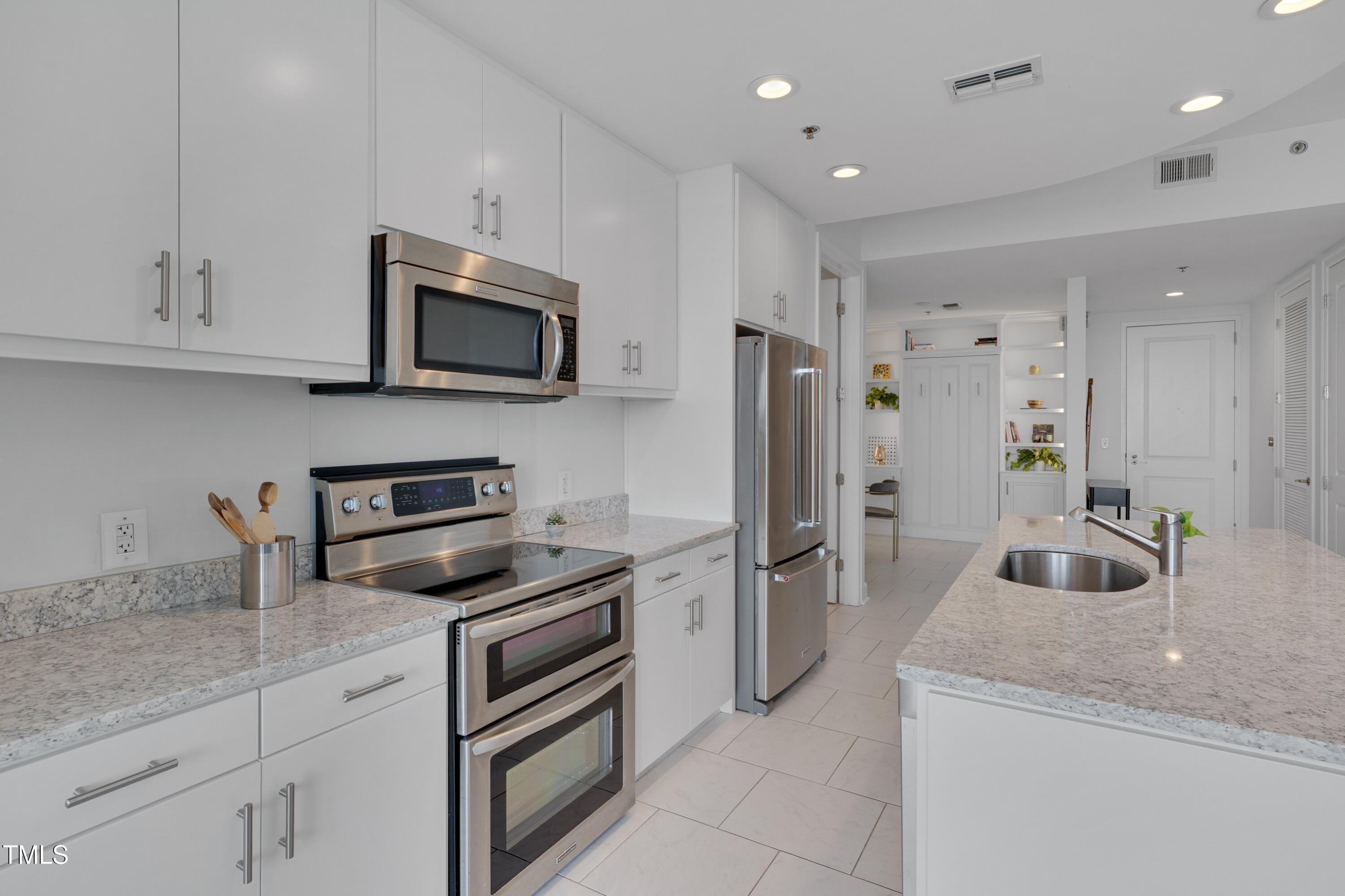 301 Fayetteville Street, Unit 2611 Raleigh, NC 27601 - Photo 16 of 44 a kitchen with granite countertop a sink and stainless steel appliances