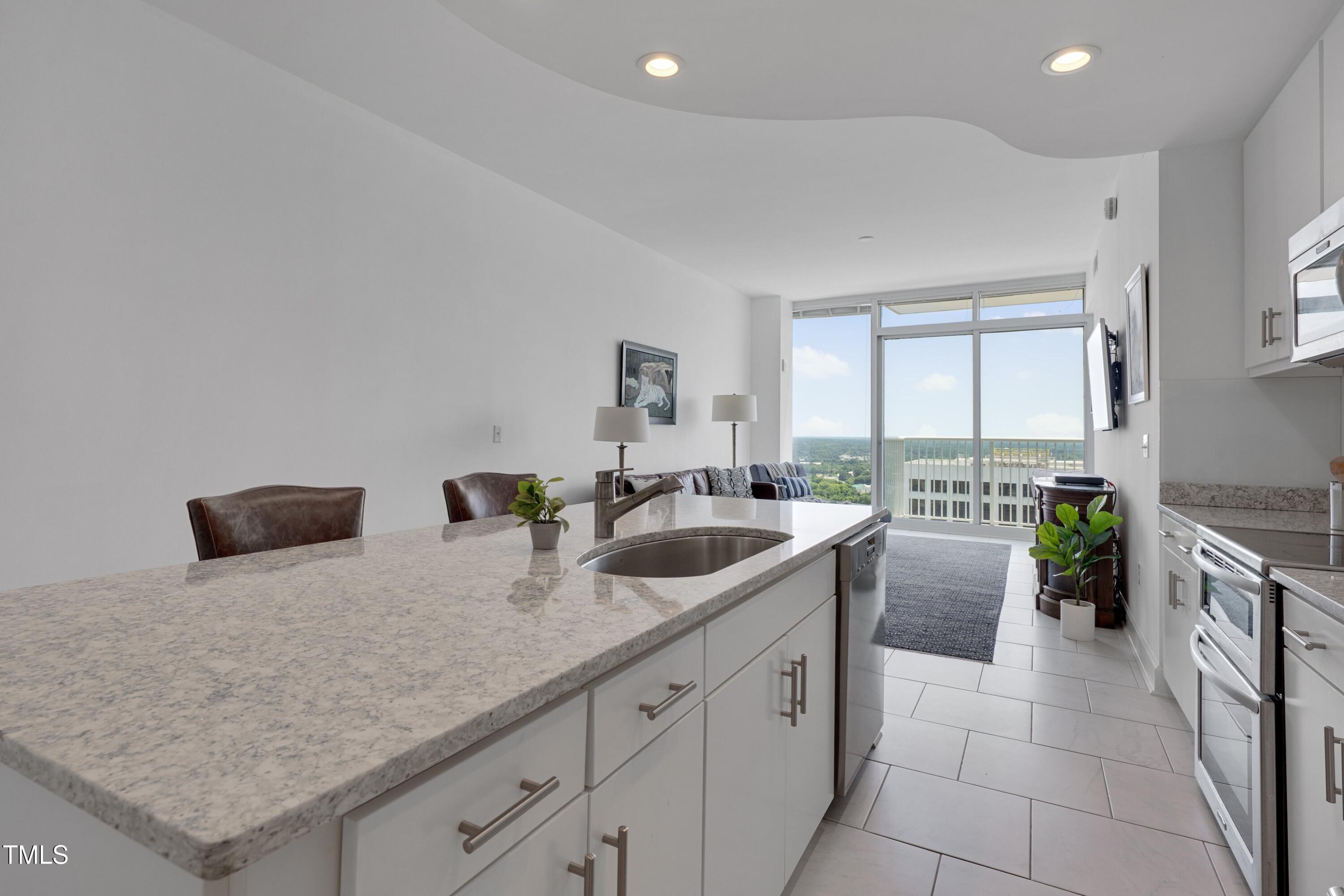 301 Fayetteville Street, Unit 2611 Raleigh, NC 27601 - Photo 17 of 44 a kitchen with a stove a sink and a refrigerator