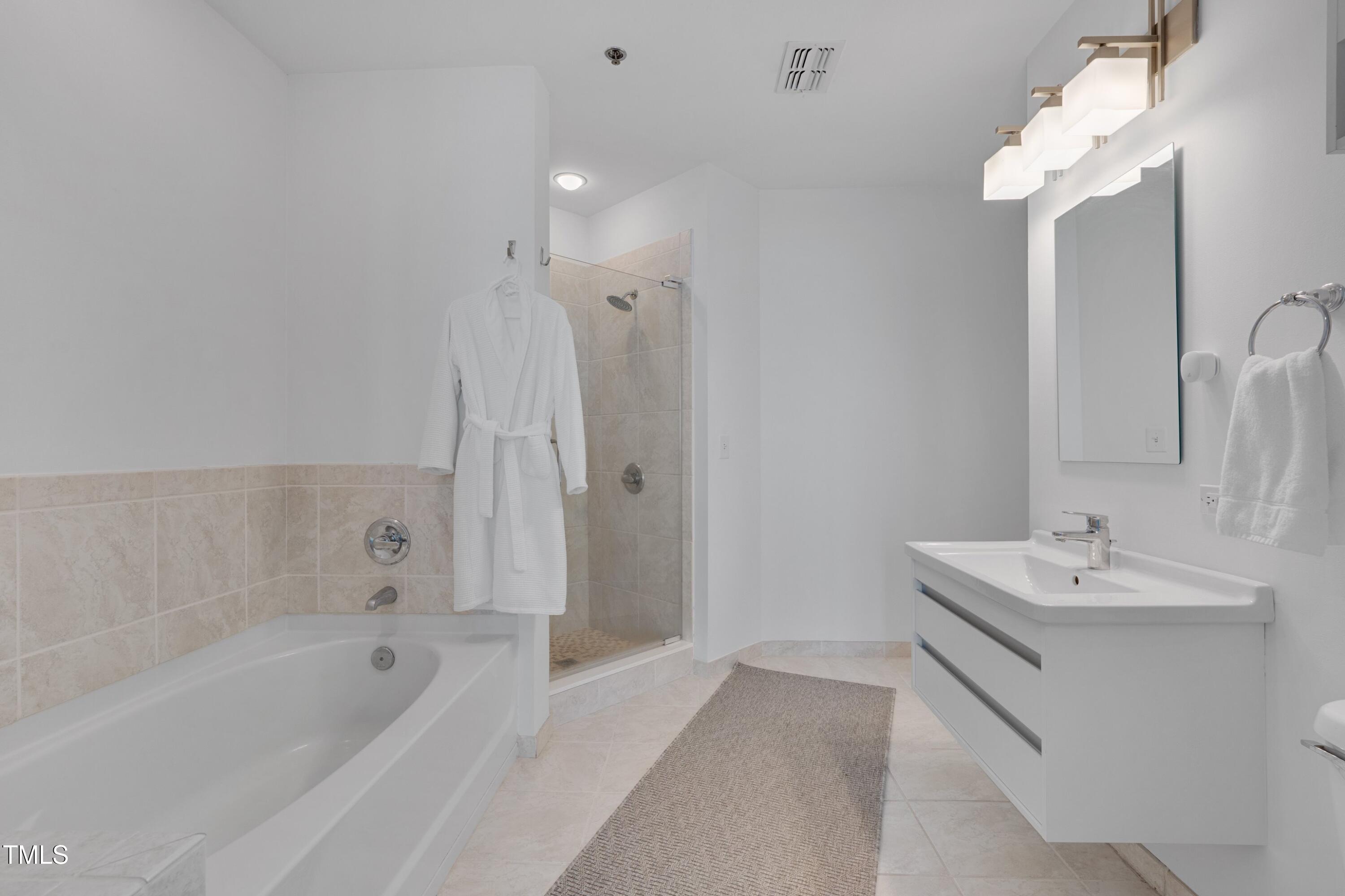 301 Fayetteville Street, Unit 2611 Raleigh, NC 27601 - Photo 21 of 44 a bathroom with a bathtub a sink and a mirror