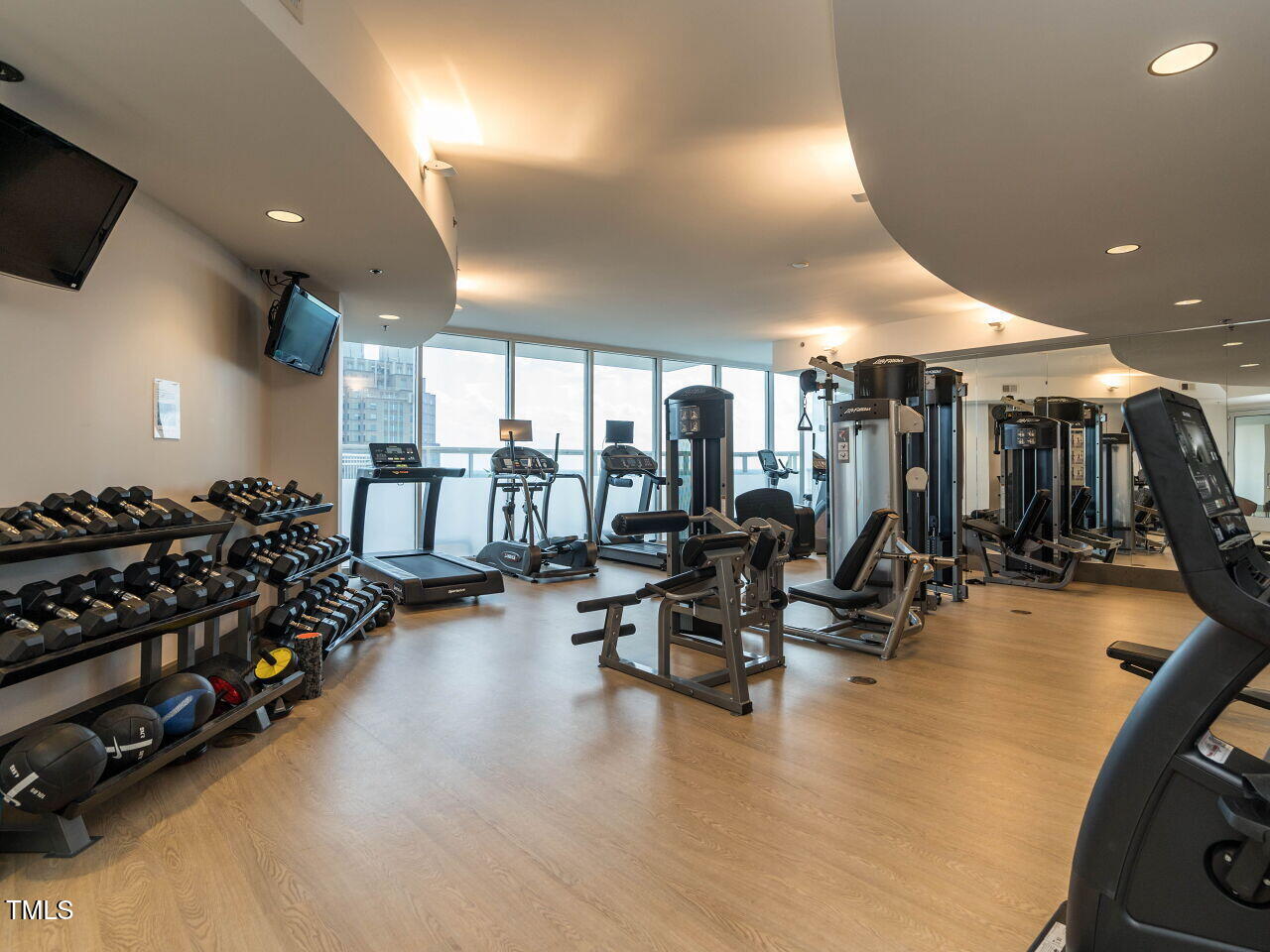 301 Fayetteville Street, Unit 2611 Raleigh, NC 27601 - Photo 39 of 44 a room with lots of gym equipment and a large window