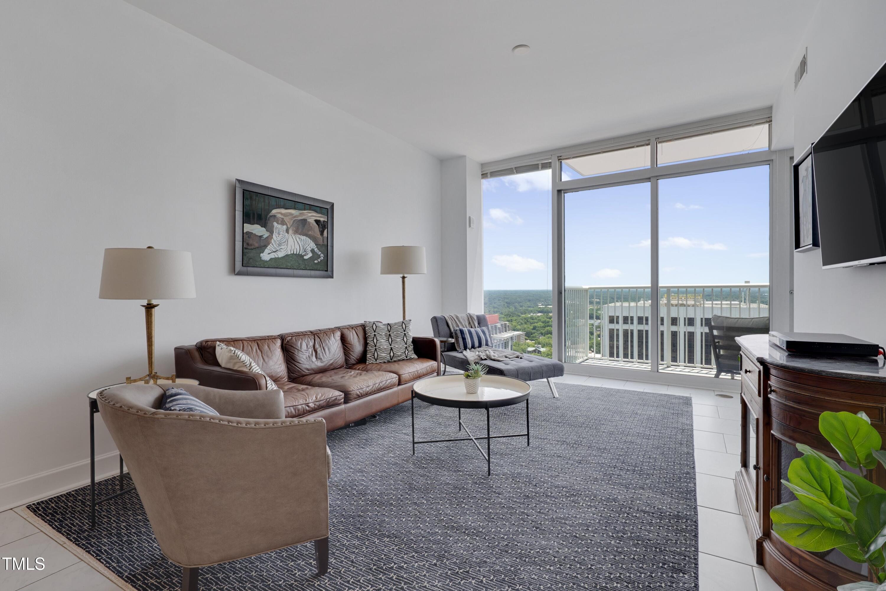 301 Fayetteville Street, Unit 2611 Raleigh, NC 27601 - Photo 4 of 44 a living room with furniture and a floor to ceiling window