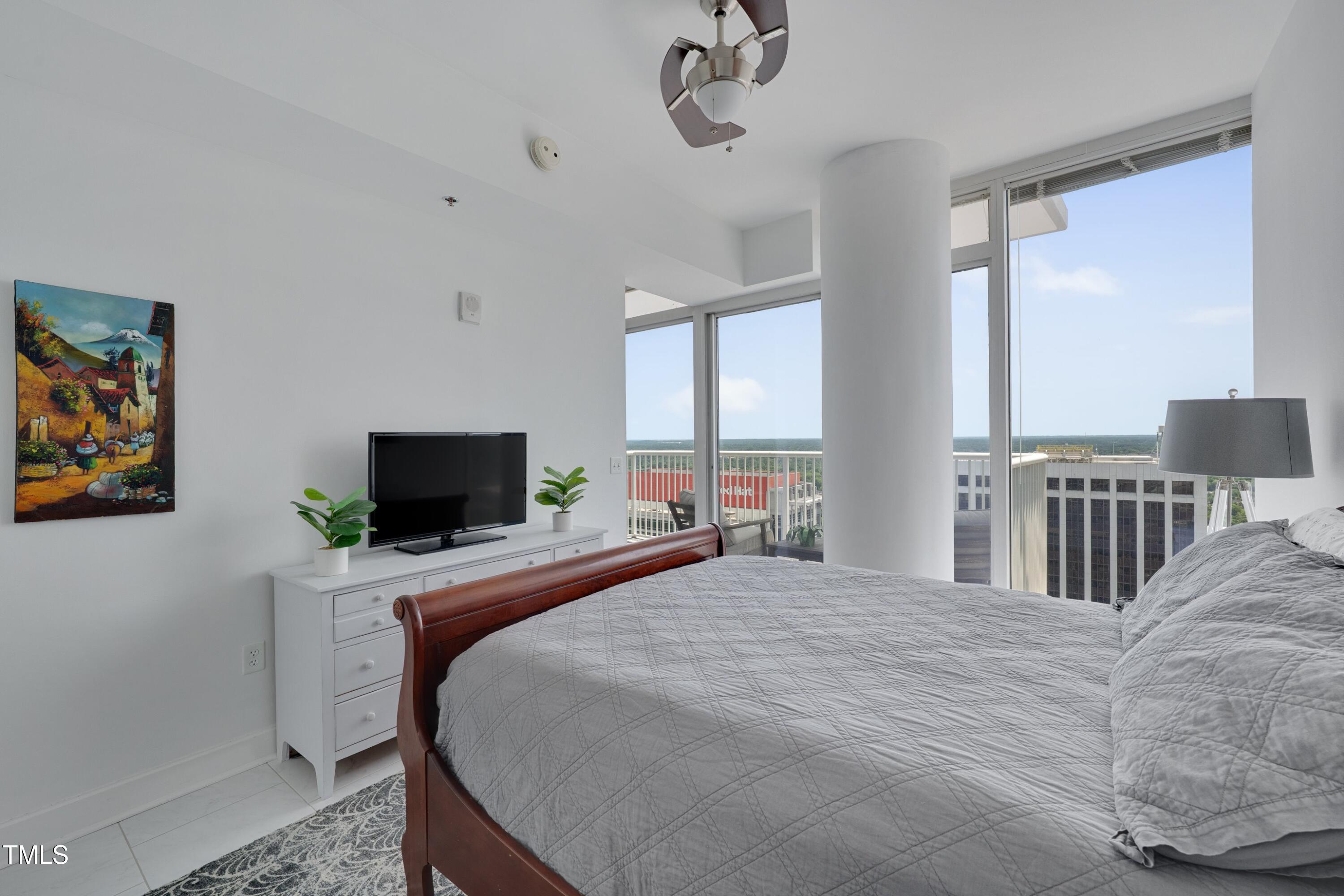 301 Fayetteville Street, Unit 2611 Raleigh, NC 27601 - Photo 9 of 44 a bedroom with a bed and a flat screen tv