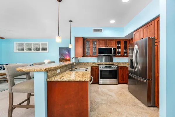 a kitchen with granite countertop a refrigerator stove and oven