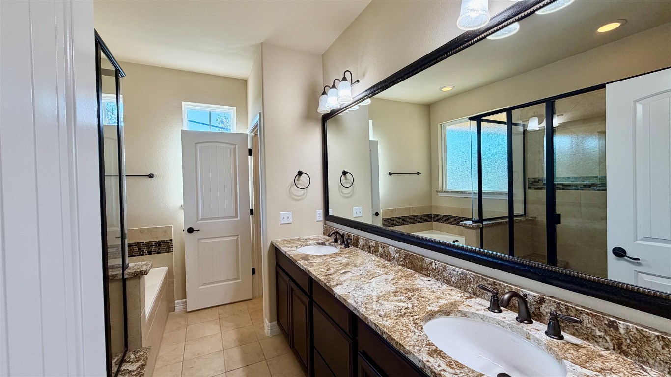12300 Terraza Circle, Unit TH10 Austin, TX 78726 - Photo 15 of 36 a bathroom with a granite countertop double vanity sink and mirror